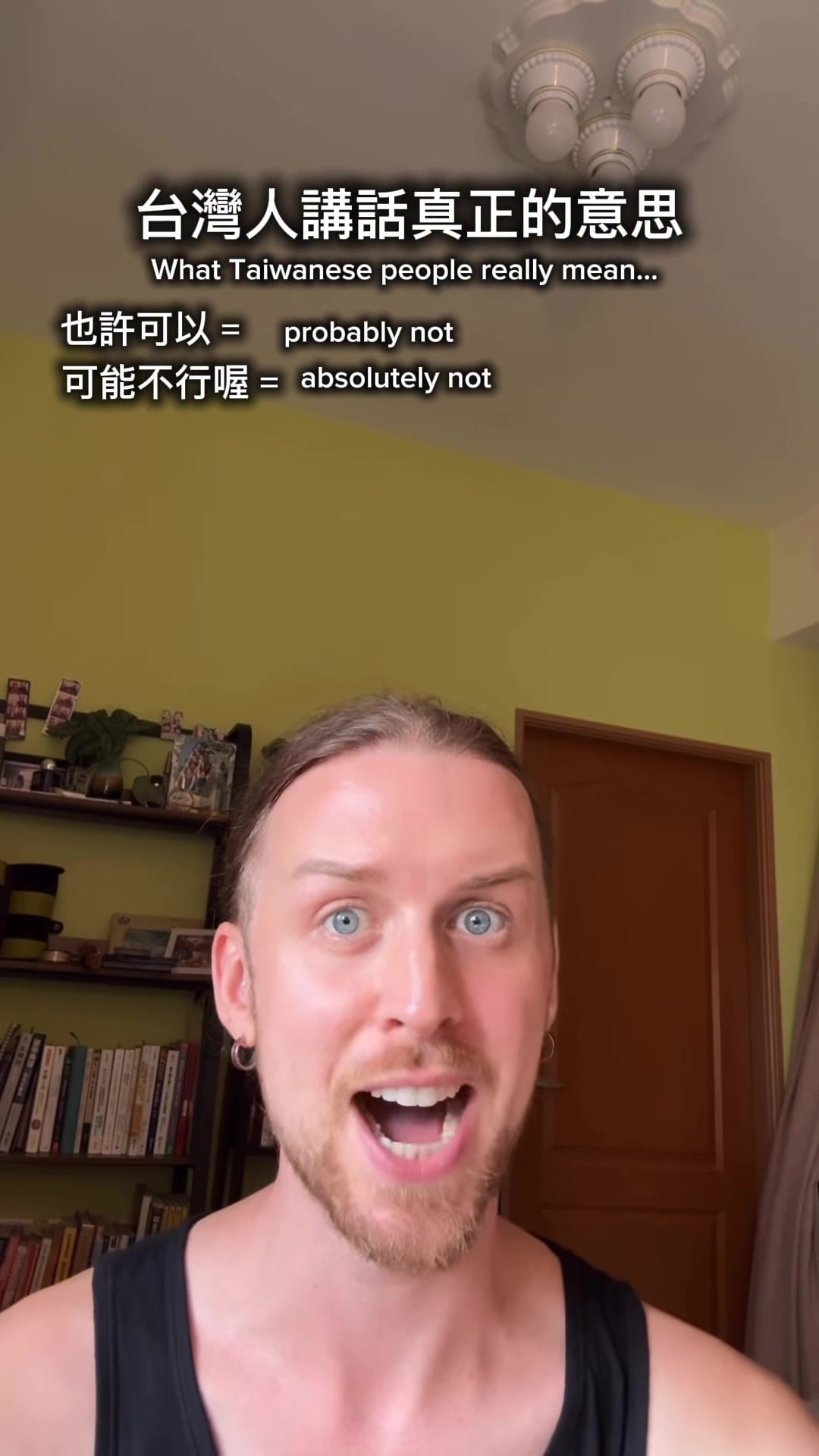 Ellery, wearing a black tank top, raises his eyebrows beneath a bilingual title and two joke translations: ‘也許可以 = probably not’ and ‘可能不行喔 = absolutely not.’